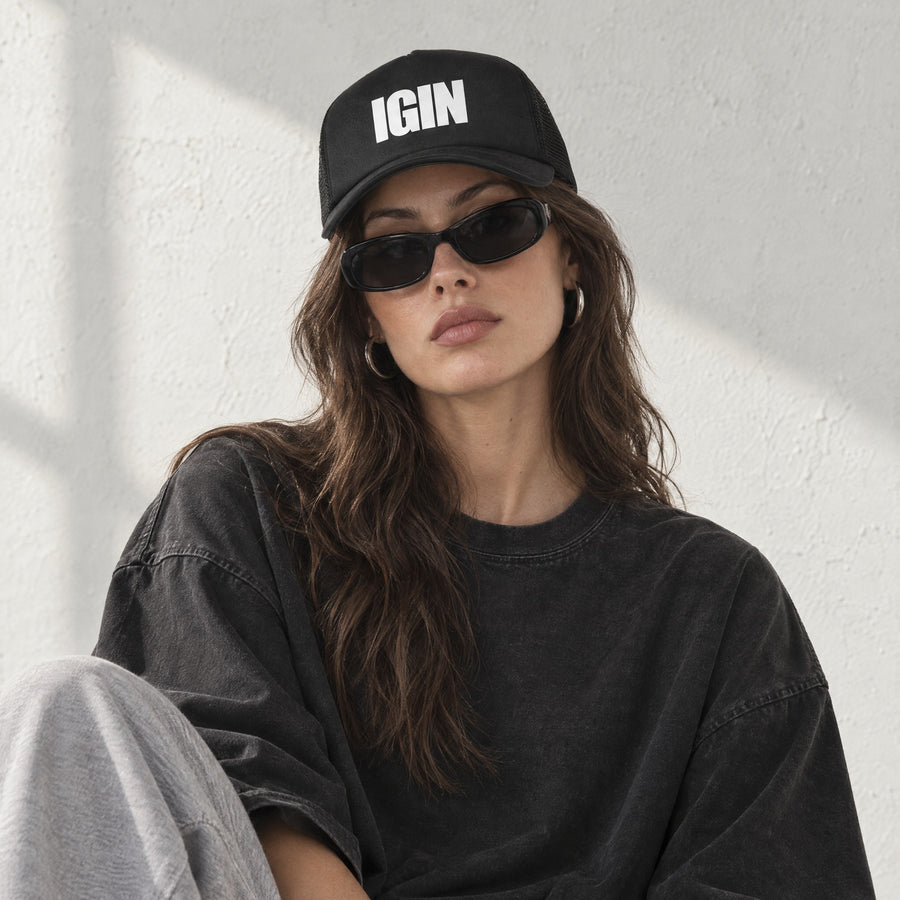Model wearing the IGIN Foam Trucker, front view, in a sunlit studio