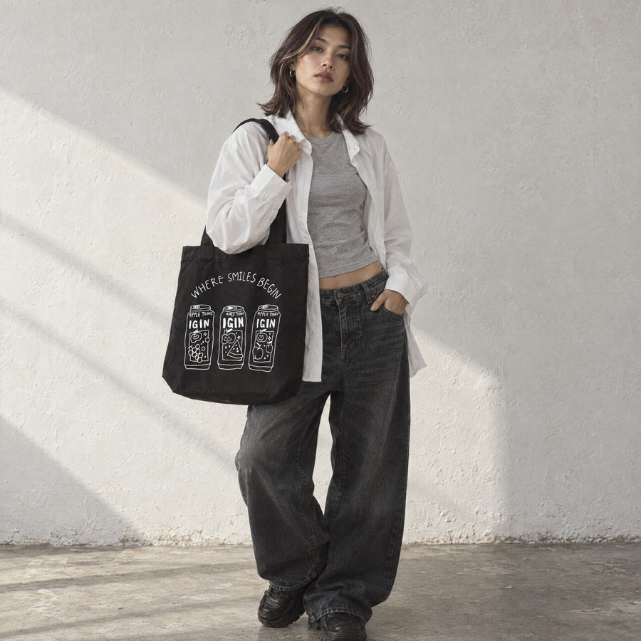 Model carrying the Where Smiles Begin Shoulder Tote on her shoulder in a sunlit studio