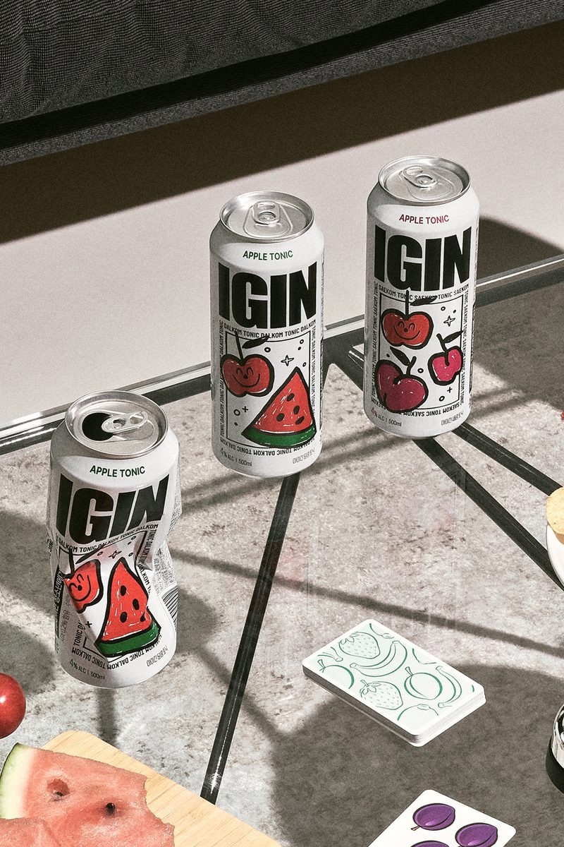 Apple Tonic cans and playing cards on a marble table