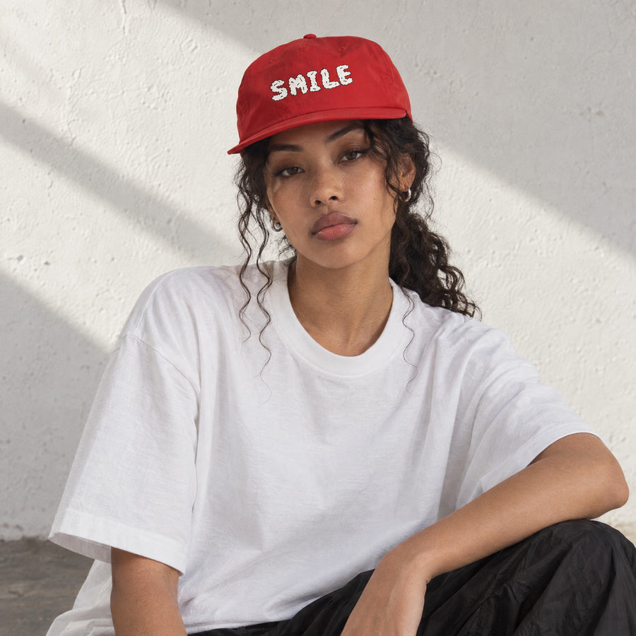 Model wearing the Smile Surf Cap, front view, in a sunlit studio