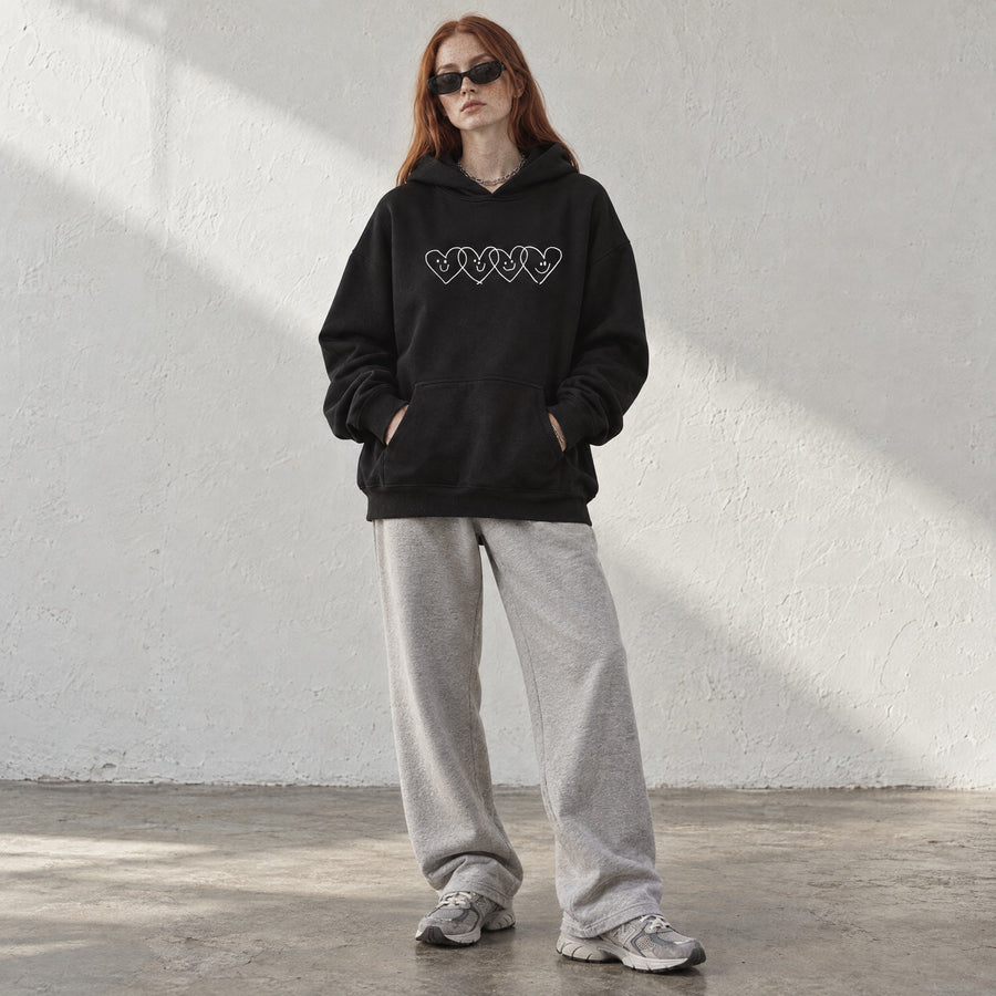 Model wearing the Wanted Relax Hoodie, front view, in a sunlit studio
